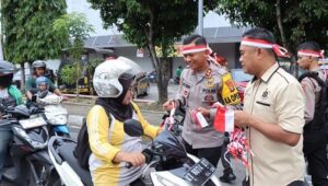 Kapolres Bontang, AKBP Alex FL Tobing SIK, bersama jajarannya menggelar aksi berbagi bendera dan merchandise di Simpang 3 Ramayana pada Kamis, 8 Agustus 2024.