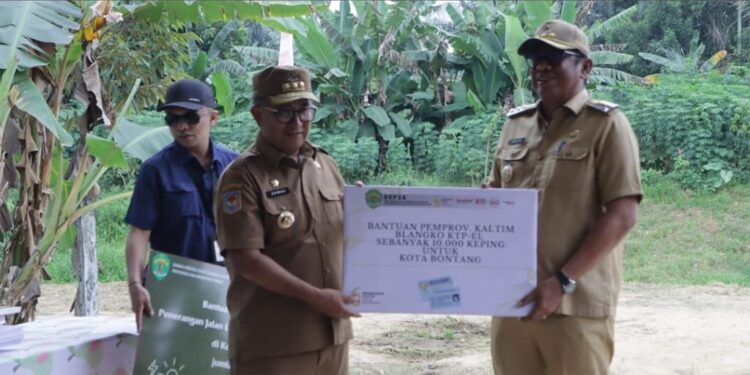 Pj Gubernur Kaltim Akmal Malik memberikan bantuan secara simbolis kepada Wali Kota Bontang Basri Rase di tengah kunjungannya ke turap Sungai Bontang, Selasa 11 Februari 2025.