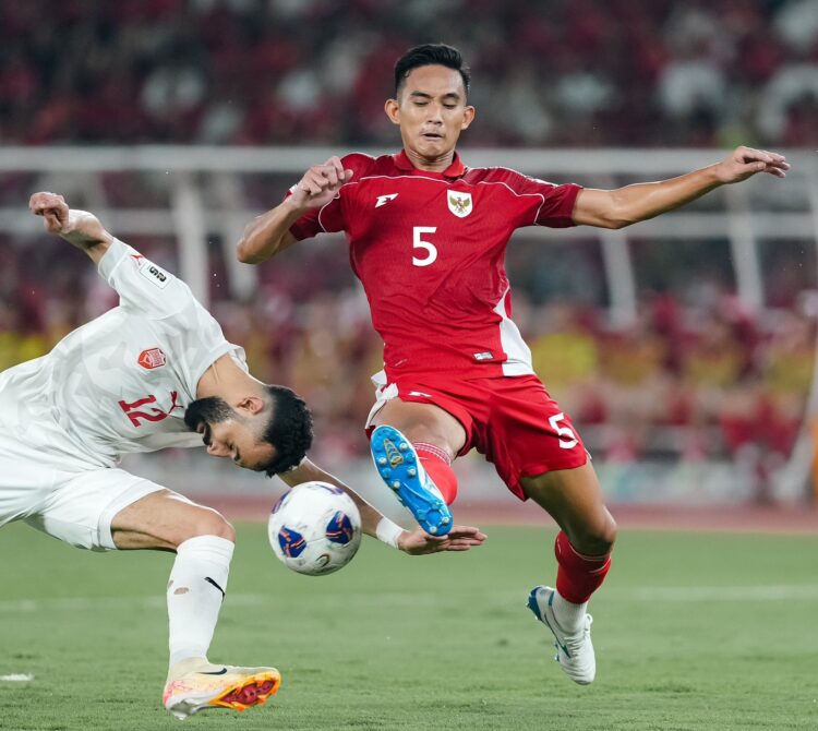 Pemain Timnas Indonesia, Rizky Ridho saat berduel denga pemain Bahrain.