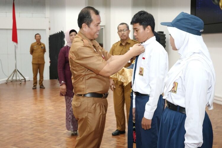 Staf Ahli Bidang Pembangunan, Kemasyarakatan, dan SDM Sekretariat Daerah Kota Bontang, Asdar Ibrahim melepas atribut siswa SMPN 6 Bontang dalam momen perpisahan dan pelepasan.